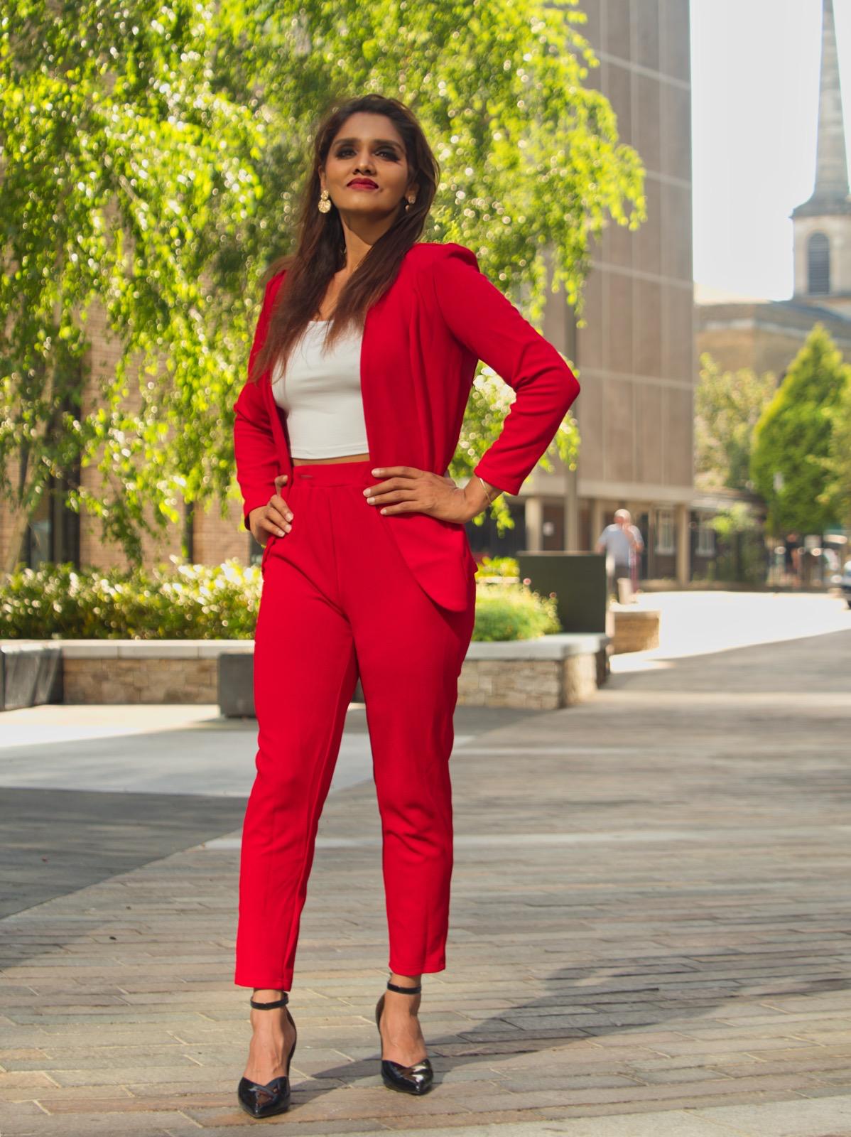 Dr Pragnya standing outdoors in a red suit